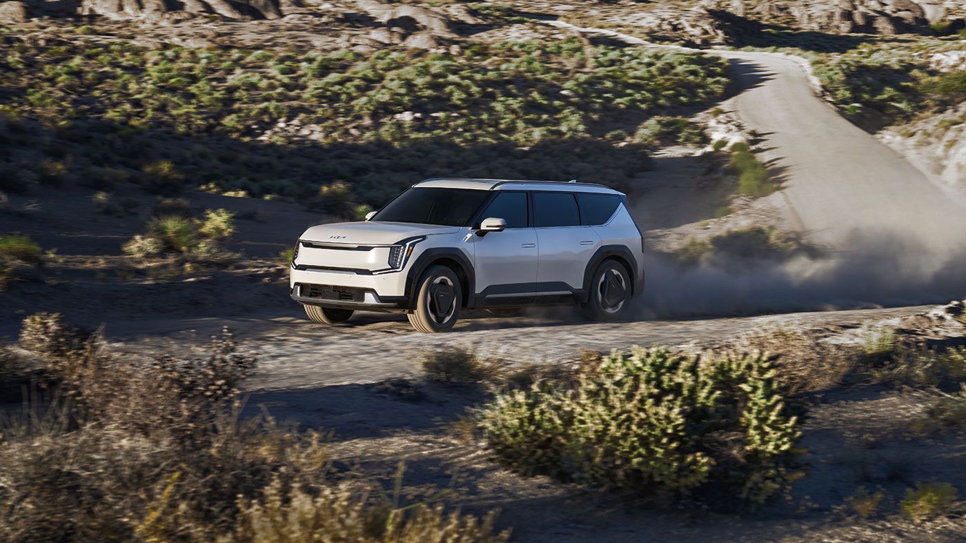 Vue latérale du Kia EV9 2025 sur route de sable en pleine puissance